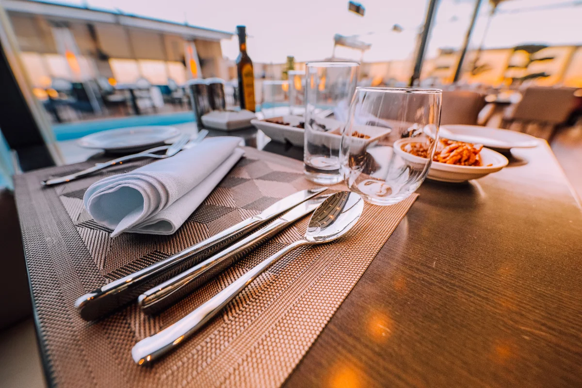 Mesa posta ao entardecer, no terraço, com os primeiros pratos servidos